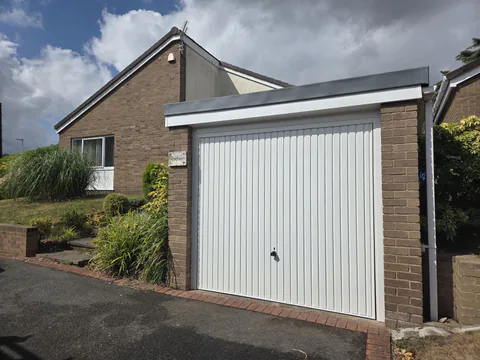 White vertically ribbed up-and-over garage door